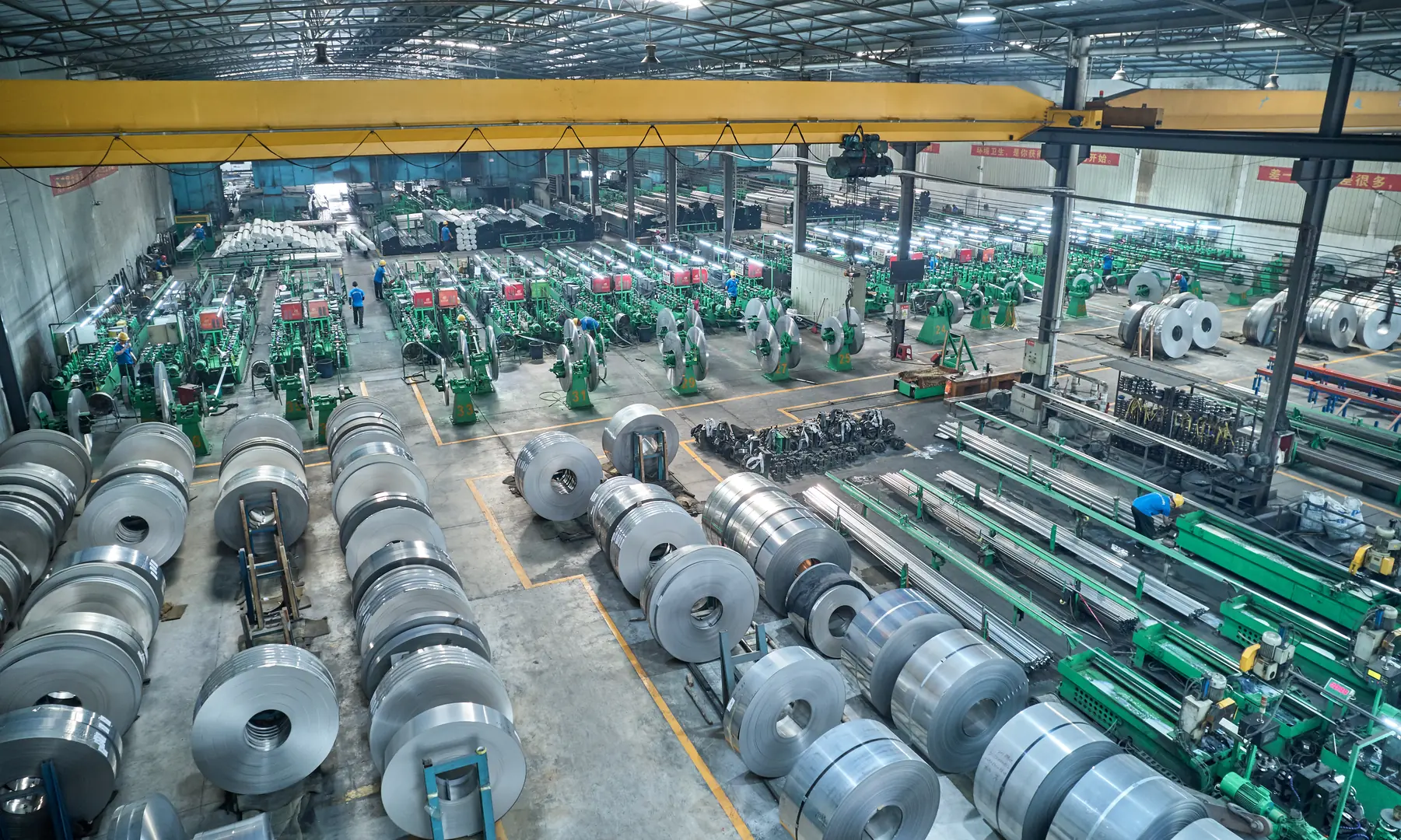 Inside view of XZS factory showcasing stainless steel coil processing and advanced welding pipe production lines.