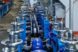 Close-up view of industrial stainless steel tube welding machinery in a factory setting