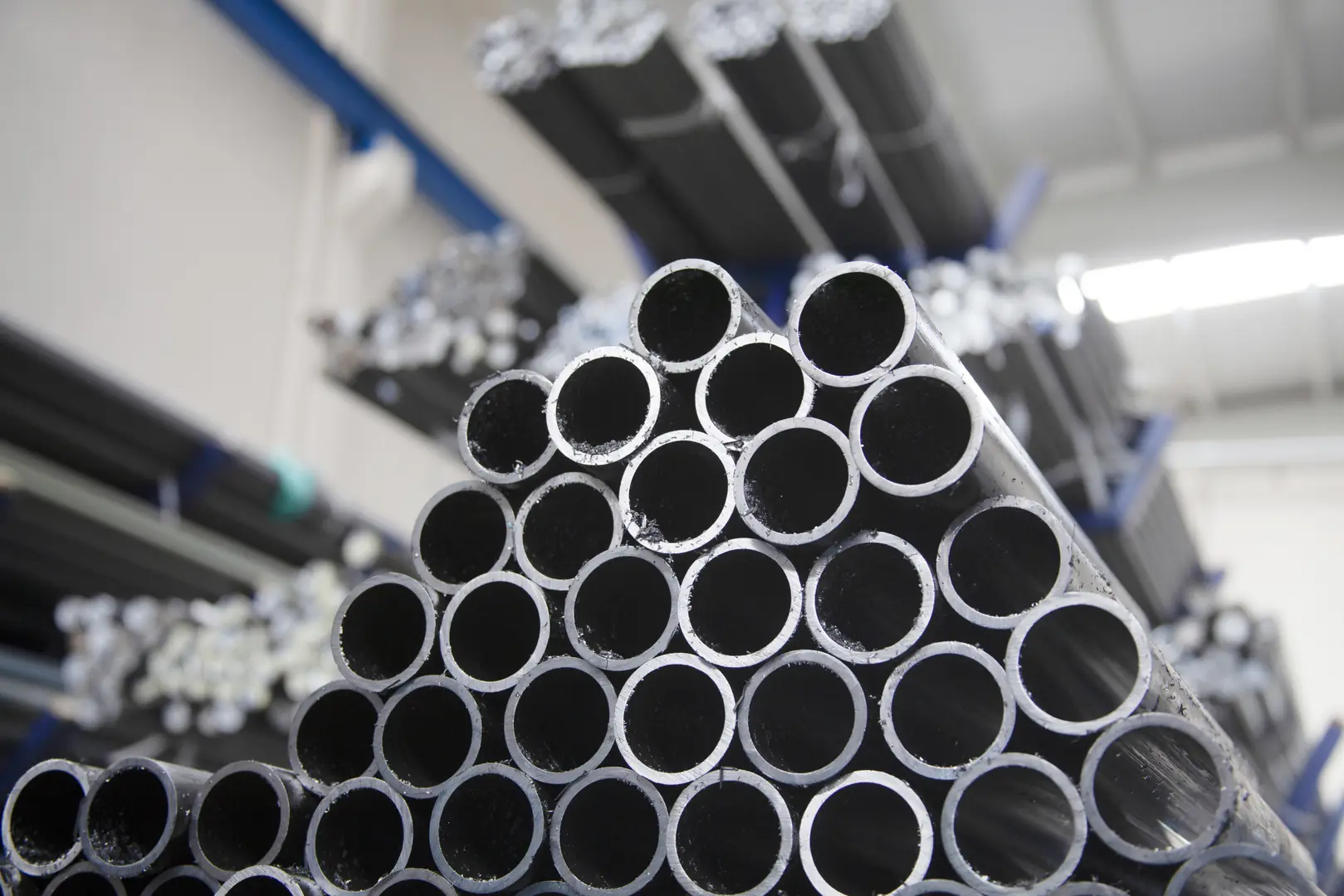 Stacked precision stainless steel welded pipes in a factory setting