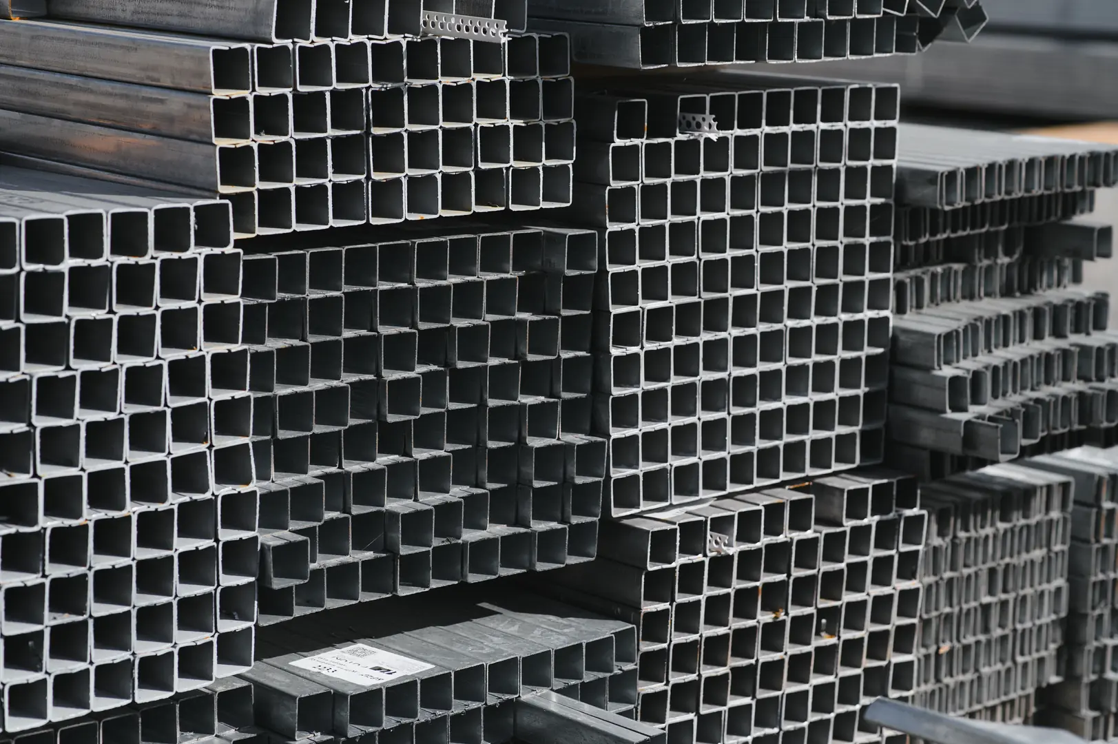 Close-up view of stacked square industrial steel tubes used for precision welding and manufacturing